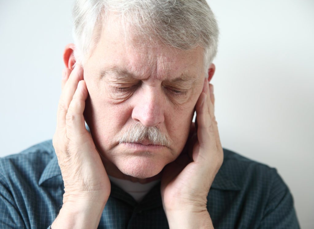An older man with a headache